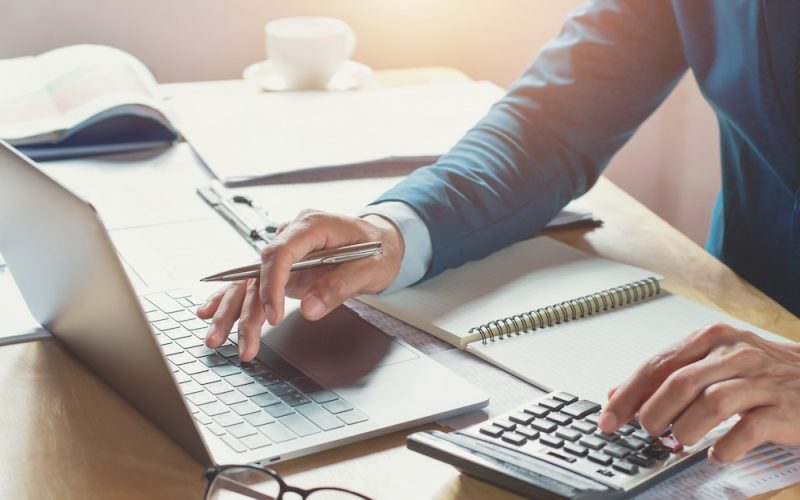 businessman working in office with using calculator and laptop. concept finance and accounting